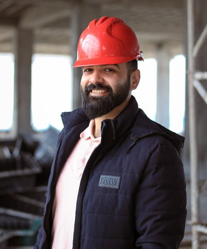 Fachkraft mit rotem Helm auf einer Baustelle — geprüfte Gewerbe österreichweit.